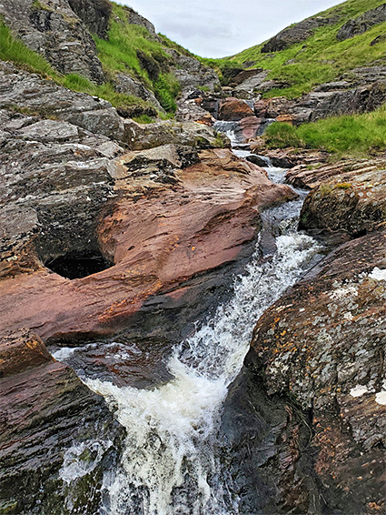 Reddish rocks beside the stream