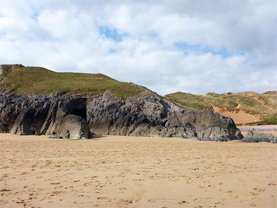 Wide beach below dark limestone cliffs